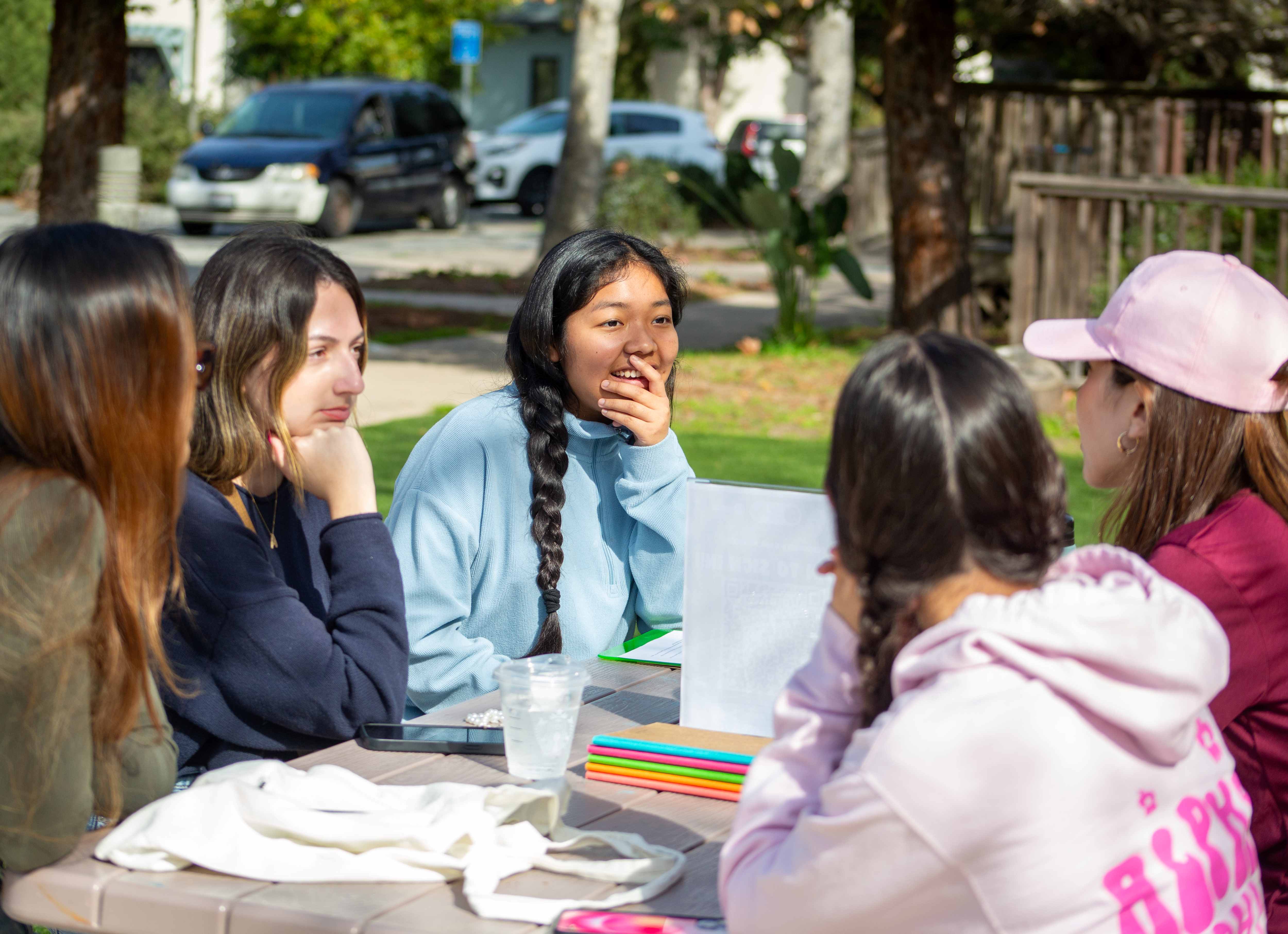 Picture of people sitting at a picnic table and having a journaling workshop