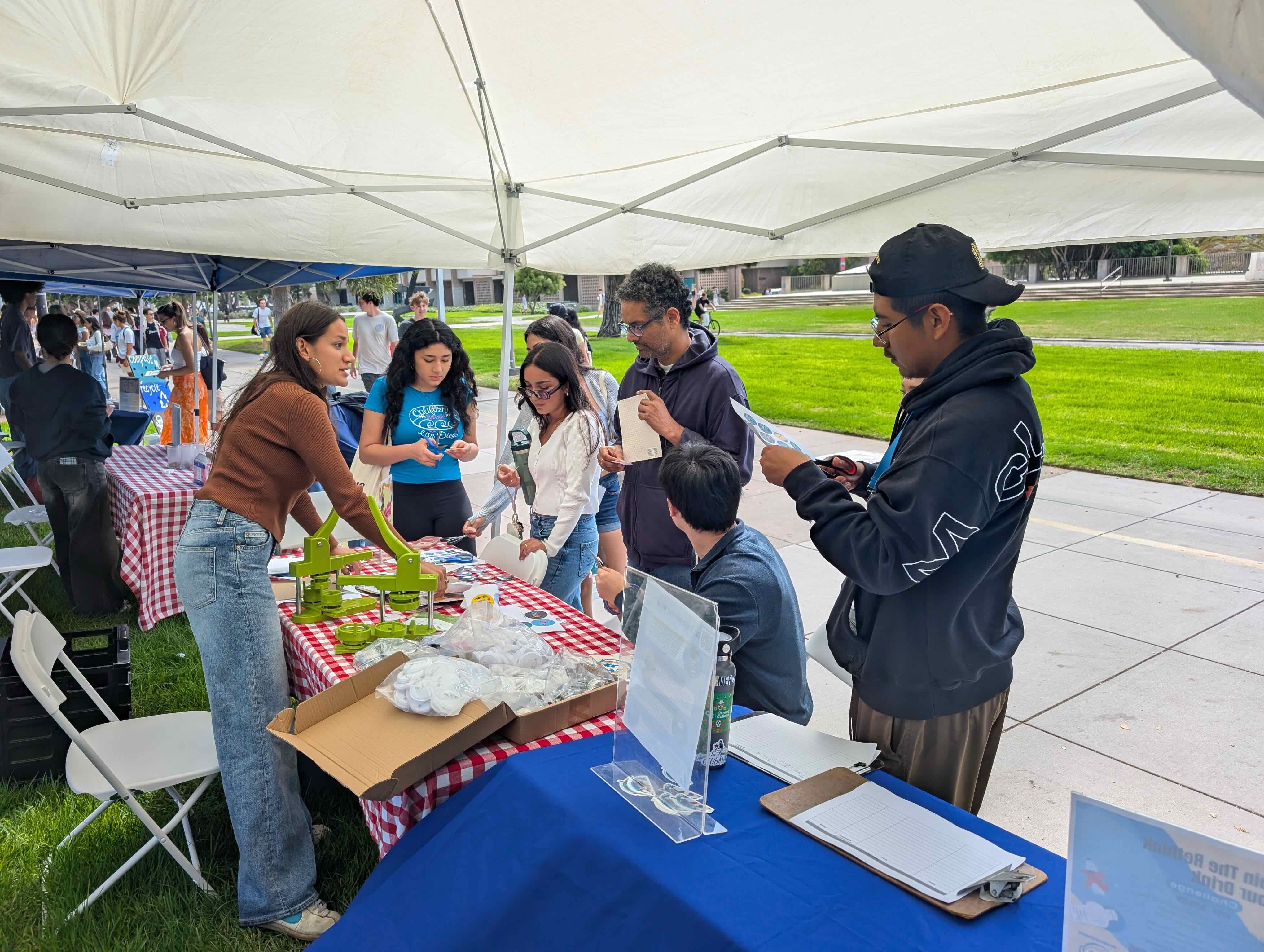 Photo of a student intern at a CFHL event talking with passersby. 